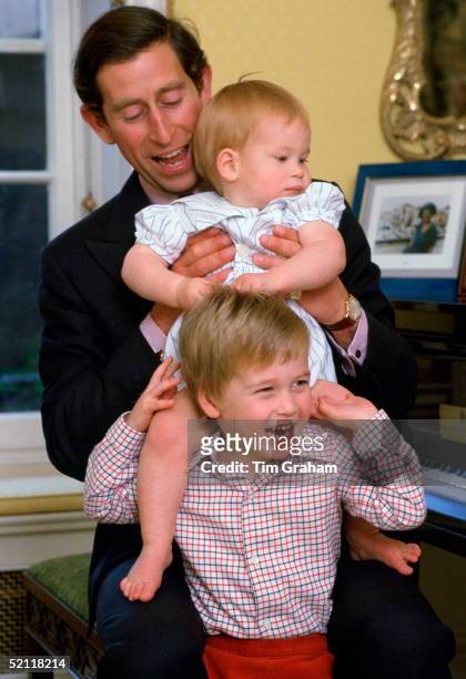 Prince Charles Laughing With His Sons As He Lifts Prince Harry Onto Prince William's Shoulders In Kensington Palace