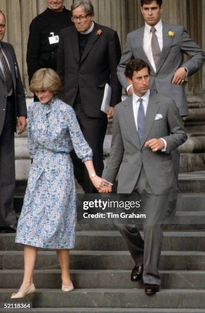Prince Charles with Lady Diana Spencer holding hands as they leave St. Paul's Cathedral after a wedding rehearsal. Behind them is Prince Andrew (.