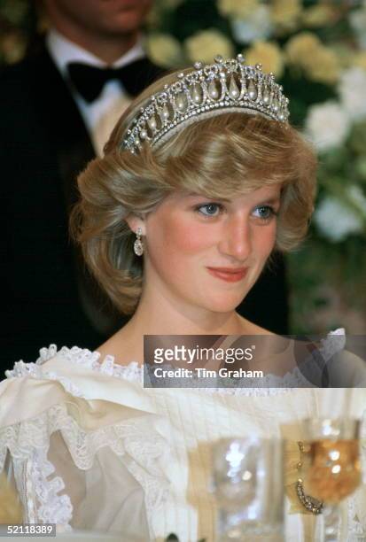 Princess Diana At A Banquet In New Zealand Wearing The Cambridge Knot Tiara With Diamond Earrings. Her Cream Silk Organza Evening Dress Is Designed...