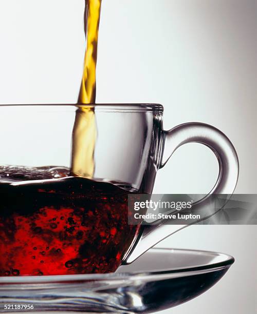 pouring tea in glass teacup - 紅茶 ストックフォトと画像