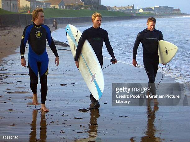 Prince William Carrying A Surfboard As He Walks With Two Friends Along The Shoreline At St Andrews In Scotland, Where He Is In The Last Year Of His...
