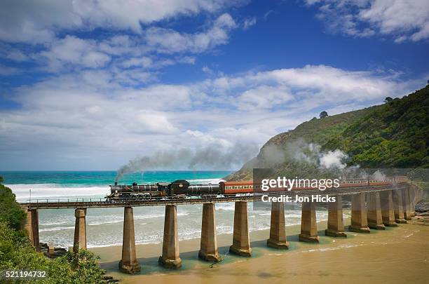 steam train crossing viaduct near ocean - garden route south africa stock pictures, royalty-free photos & images