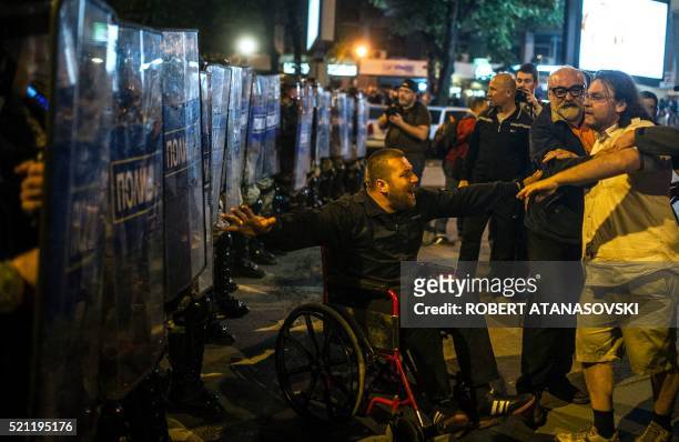 Protester in a wheelchair gestures in front of anti-riot police officers in Skopje on April 14 during a protest against the president's shock...
