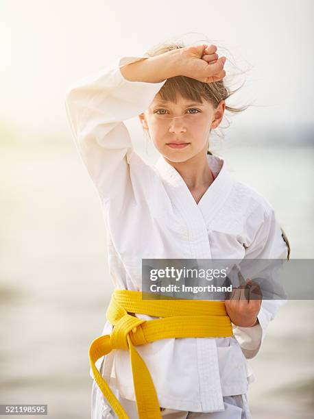 kleines mädchen üben karate am strand - karate stock-fotos und bilder