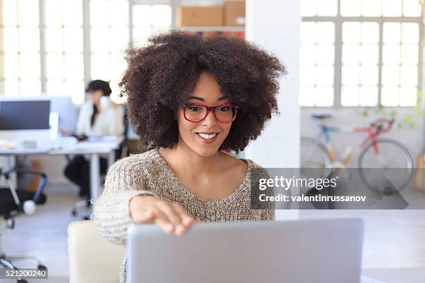 smiling female manager finishing her works at the office - beëindigen stockfoto's en -beelden