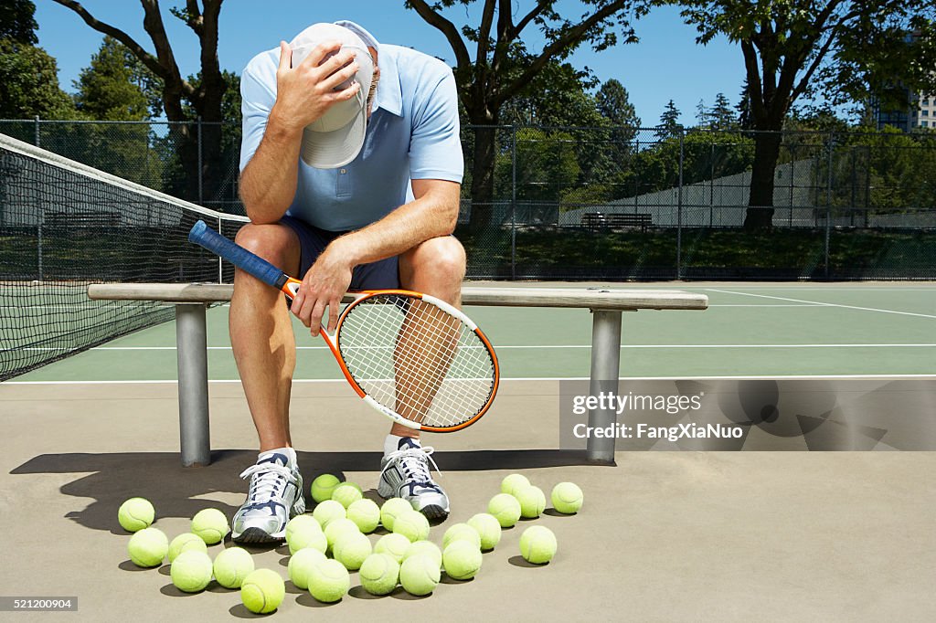 Tennis player with his head in his hands