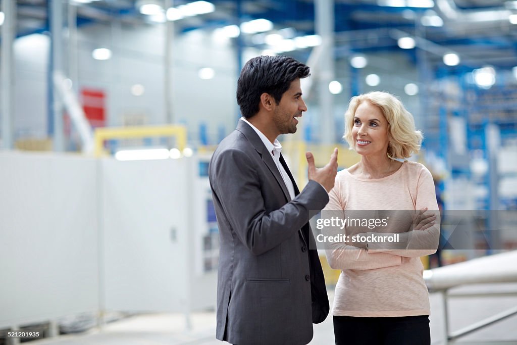 Geschäftsmann, ein Gespräch mit senior weiblichen Kollegen in Fabrik