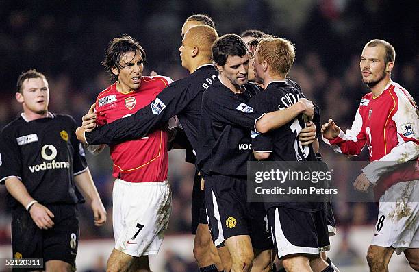 Paul Scholes of Manchester United clashes with Robert Pires of Arsenal during the Barclays Premiership match between Arsenal and Manchester United at...