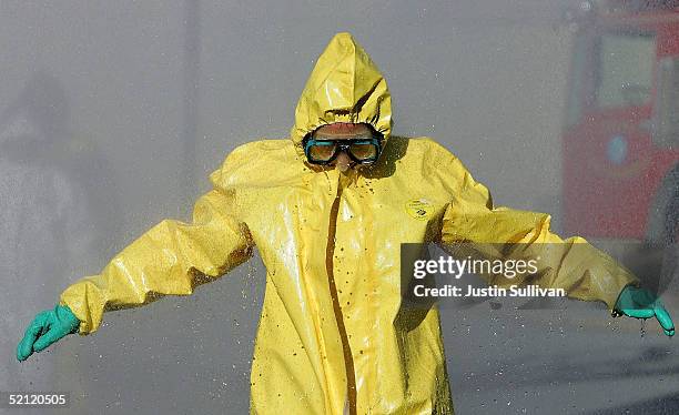 Man wearing a hazardous materials suit walks through a decontamination shower during a weapons of mass destruction training workshop February 1, 2005...