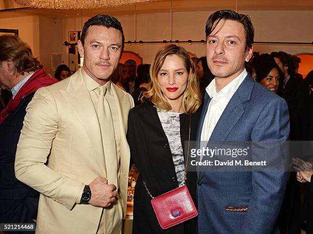 Luke Evans, wearing a Bulgari watch,, Sienna Guillory, carrying a Bulgari bag, and Enzo Cilenti attend the Bulgari flagship store reopening on New...