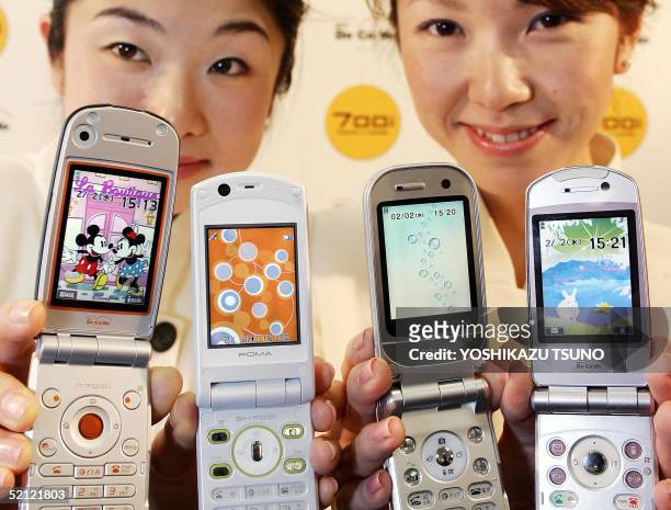 Japan's mobile communication giant NTT DoCoMo employees display the new line up of 3G mobile phone handsets 700i series, produced by NEC, Sharp,...