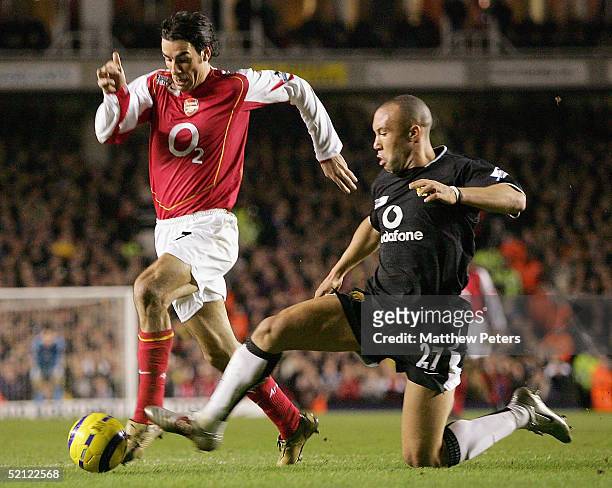 Mikael Silvestre of Manchester United fouls Robert Pires of Arsenal during the Barclays Premiership match between Arsenal and Manchester United at...