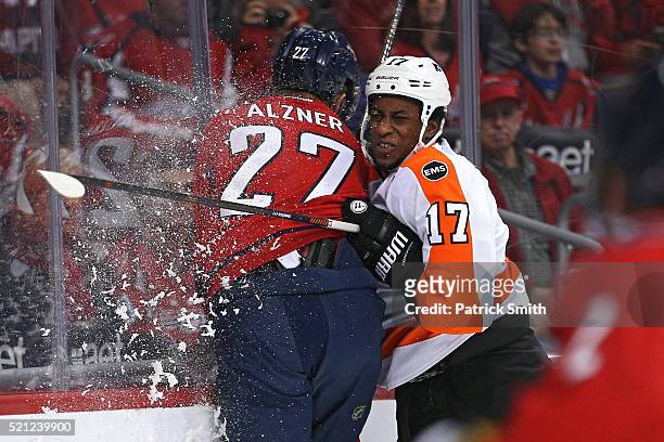 Wayne Simmonds of the Philadelphia Flyers checks Karl Alzner of the Washington Capitals during the first period in Game One of the Eastern Conference...