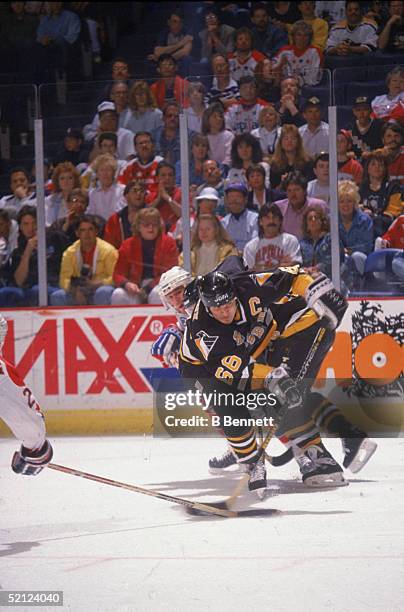 Canadian professional hockey player Mario Lemieux , captain of the Pittsburgh Penguins, tries to shoot on the Washington Capitals goal during a game...