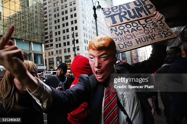 Man in a Donald Trump mask joins hundreds of other protesters and activists as they march during a demonstration near a midtown hotel which is...