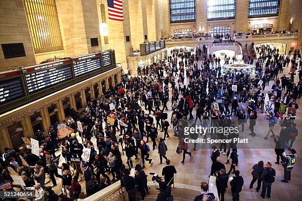 Hundreds of protesters and activists march through Grand Central Terminal during a demonstration near a midtown hotel which is hosting a black-tie...