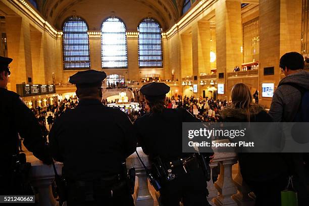 Police watch as hundreds of protesters and activists march through Grand Central Terminal during a demonstration near a midtown hotel which is...