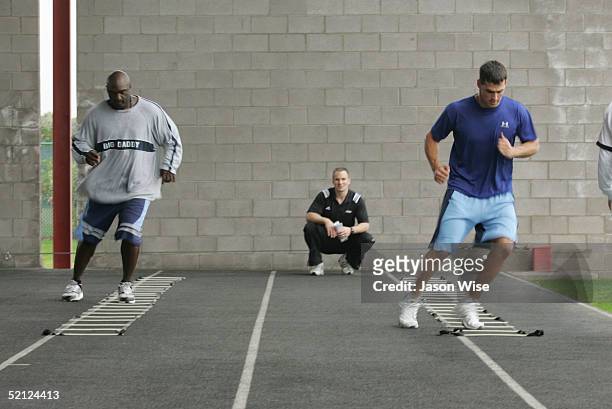 Kansas City Royals first baseman Calvin Pickering and Texas Rangers centerfielder Ricky Asadoorian perform ladder agility drills while Founder and...