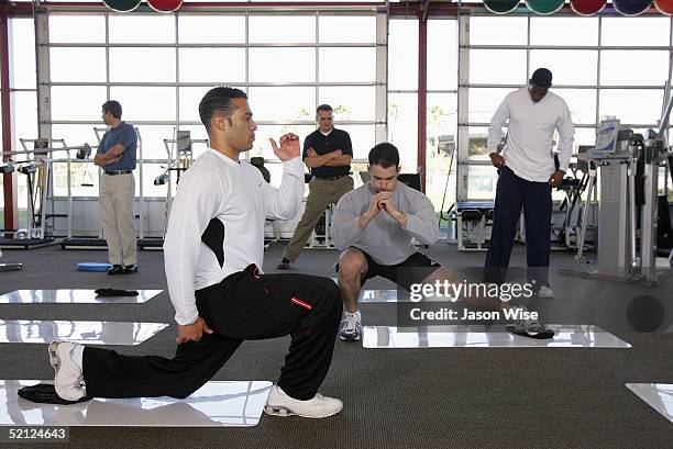 Baltimore Orioles second baseman Jerry Hairston performs slide board split squats while former Cleveland Indians infielder and current Los Angeles...
