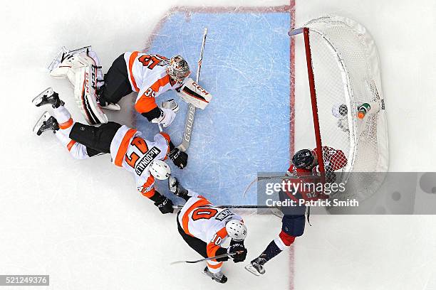 Evgeny Kuznetsov of the Washington Capitals is checked into the goal by Brayden Schenn of the Philadelphia Flyers during the third period in Game One...