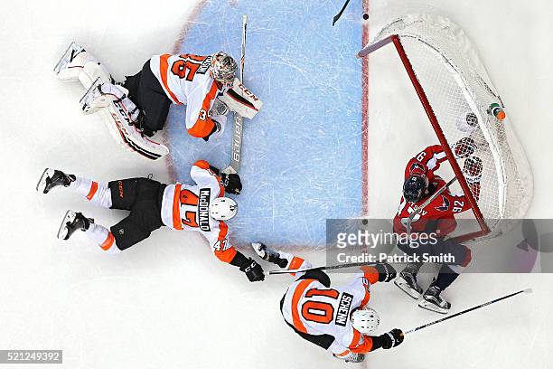 Evgeny Kuznetsov of the Washington Capitals is checked into the goal by Brayden Schenn of the Philadelphia Flyers during the third period in Game One...
