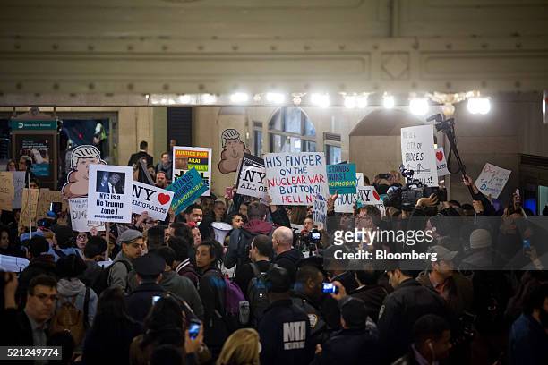 Protesters hold signs inside Grand Central Station during the New York State Republican Gala in New York, U.S., on Thursday, April 14, 2016. Despite...