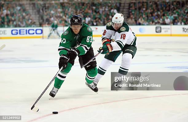 Ales Hemsky of the Dallas Stars skates the puck against Ryan Carter of the Minnesota Wild in the first period in Game One of the Western Conference...