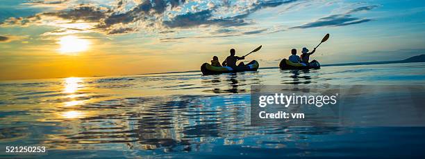 family sea kayaking at sunset - family panoramic stock pictures, royalty-free photos & images