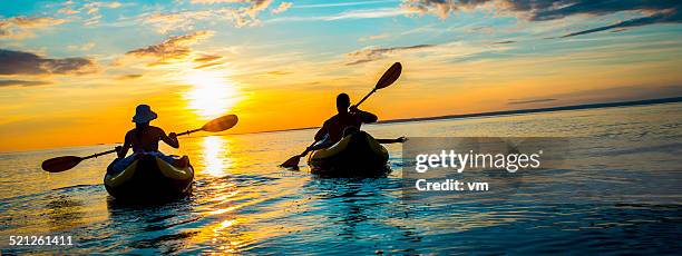 familie auf dem meer bei sonnenuntergang - sea kayaking stock-fotos und bilder