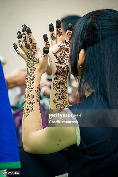 jóvenes chica examinig mehndi tatuaje en sus manos. - bangladeshi bride fotografías e imágenes de stock