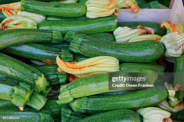 zucchini with their flowers for sale in the produce market of gallipoli, puglia, italy - courgette stock pictures, royalty-free photos & images