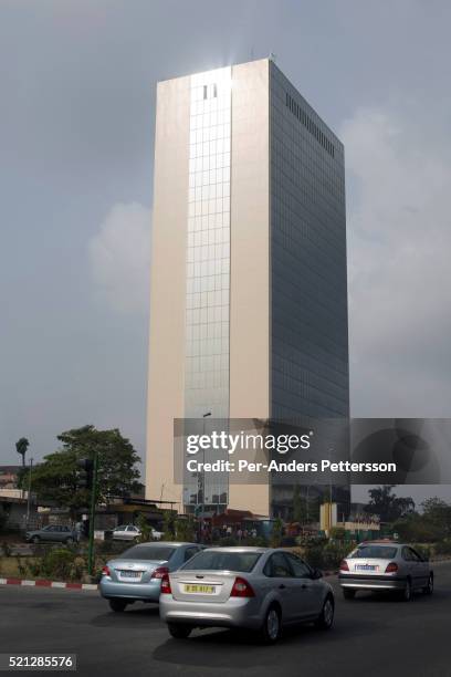 People walk past the provisional headquarters of the African Development Bank in Abidjan, Ivory Coast. The Bank moved to Tunisia over 10 years ago...