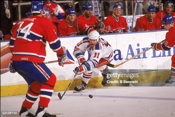 New York Rangers center Mark Messier plays the puck away from Montreal Canadiens right wing Mark Recchi as Canadiens defenseman Peter Popovic looks...