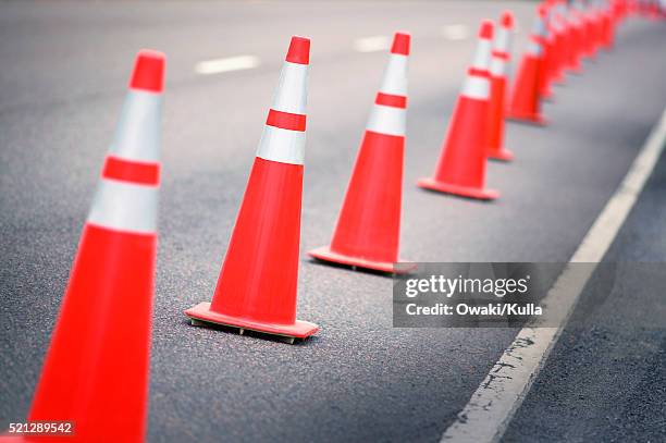 traffic cones on highway - verkehrshütchen stock-fotos und bilder