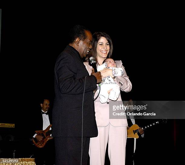 Singer Lou Rawls, his wife Nina Malek Inman and baby Aiden Allen Rawls appear on stage at the inaugural event of the Lou Rawls Center For The...