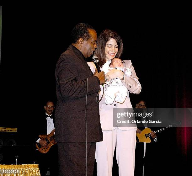 Singer Lou Rawls, his wife Nina Malek Inman and baby Aiden Allen Rawls appear on stage at the inaugural event of the Lou Rawls Center For The...