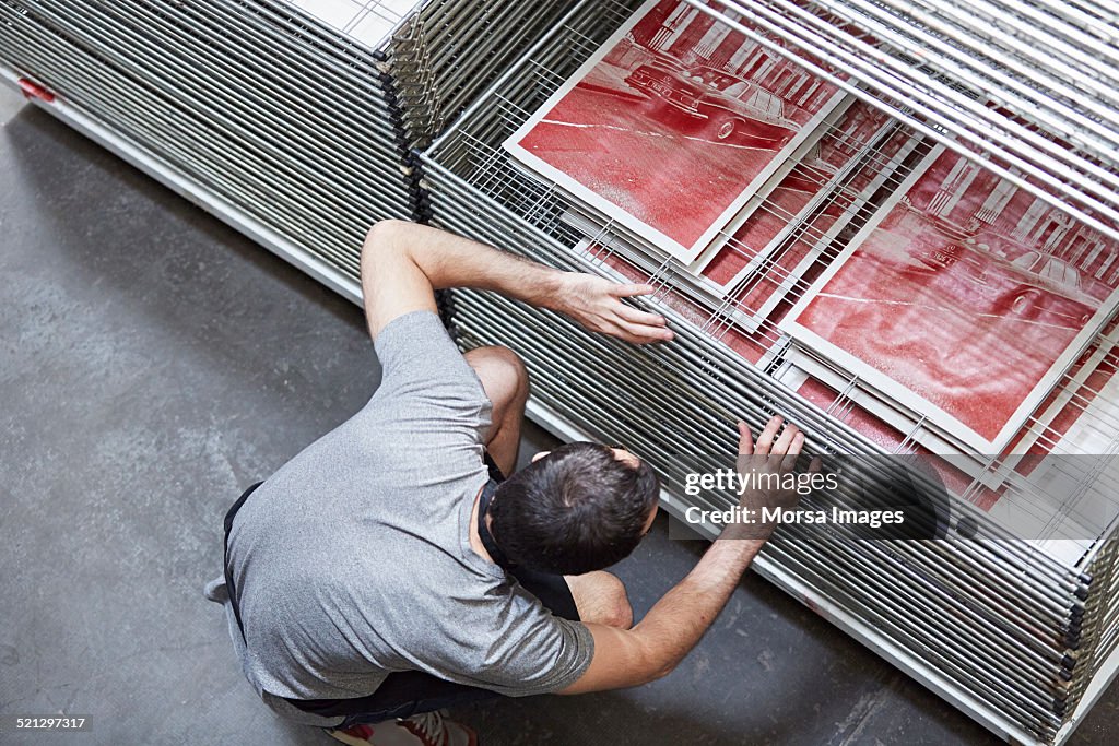 Silk screen worker inspecting prints