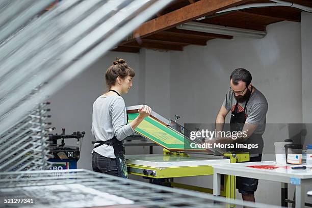 man and woman preparing a screen to print - silk screen stock pictures, royalty-free photos & images