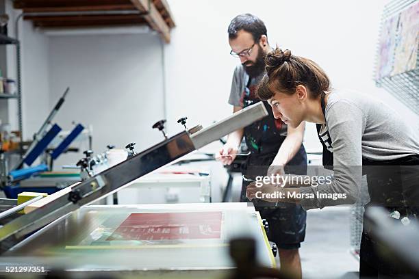 woman checking the results of the printing process - ausdrucken stock-fotos und bilder