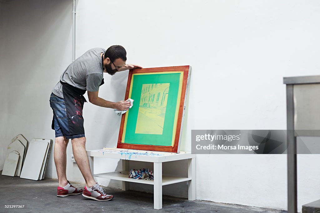 Man cleaning a silk screen