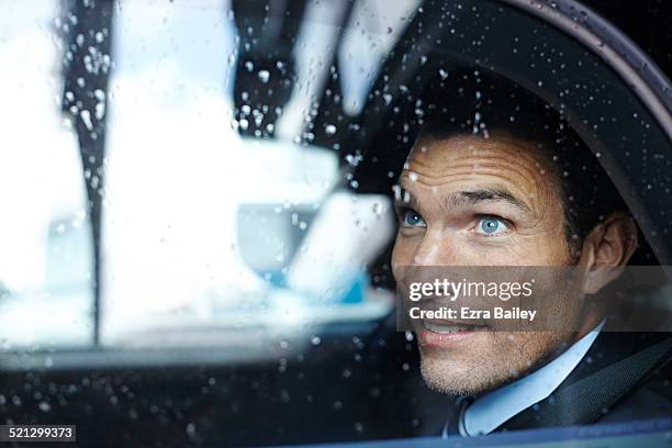 a businessman looks from a taxi window - businessman taxi stock-fotos und bilder