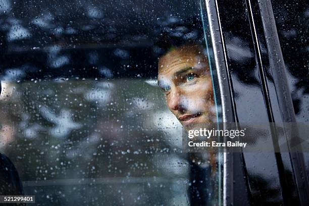 businessman looks out of a taxi window. - mann 40 bis 50 business auto stock-fotos und bilder