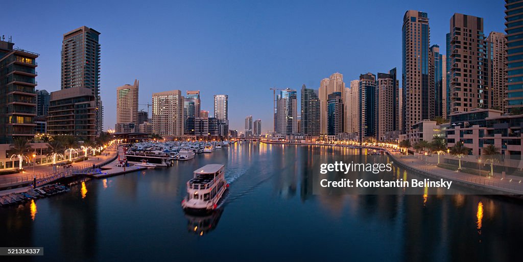 Panoramic Dubai Marina with boat at dawn