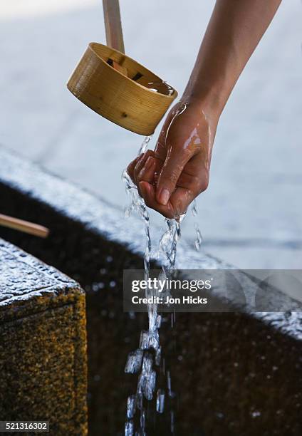 symbolic hand washing at a buddhist shrine. - yasaka shrine stock pictures, royalty-free photos & images