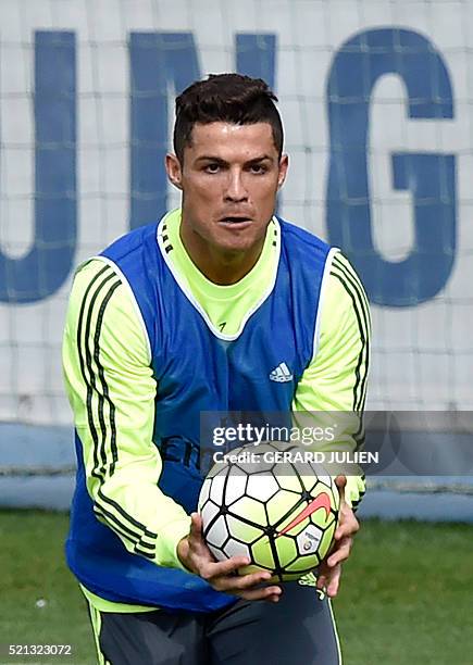 Real Madrid's Portuguese forward Cristiano Ronaldo catches a ball during a training session at Valdebebas training ground in Madrid on April 15 on...