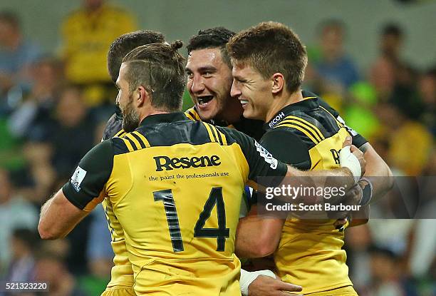 Beauden Barrett of the Hurricanes is congratulated by Cory Jane and his teammates after scoring a try during the round eight Super Rugby match...