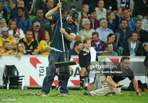 Groundmen work to repair large divots of turf that were ripped up after a scrum during the round eight Super Rugby match between the Rebels and the...