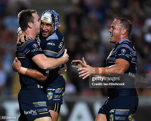 Michael Morgan of the Cowboys celebrates after scoring a try with Johnathan Thurston and Matthew Scott during the round seven NRL match between the...