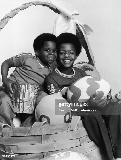 American actors Gary Coleman and Todd Bridges pose in an Easter basket with oversized Easter eggs in a promotional photo for the NBC television...