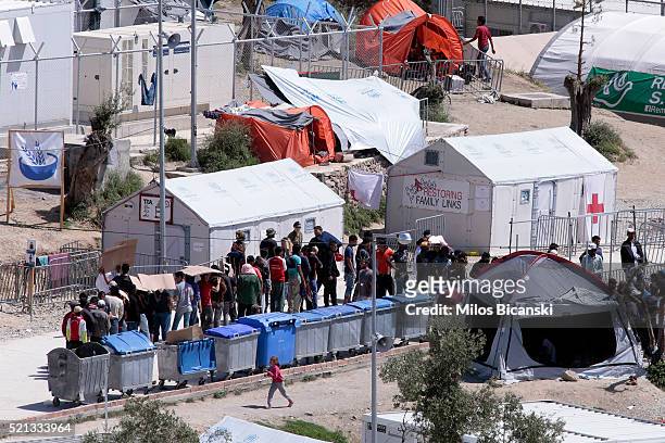 People queue at the Moria refugee camp where asylum-seekers wander the complex on April 15, 2016 in Mytilini on Lesbos island in Greece. Pope Francis...